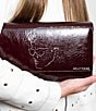 Color:Berry - Image 4 - Breckin Patent Calfskin Leather Etched Face Side Tassel Crossbody Bag